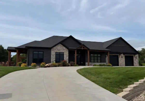 Modern ranch home with stone accents and a long curved concrete driveway in central Illinois
